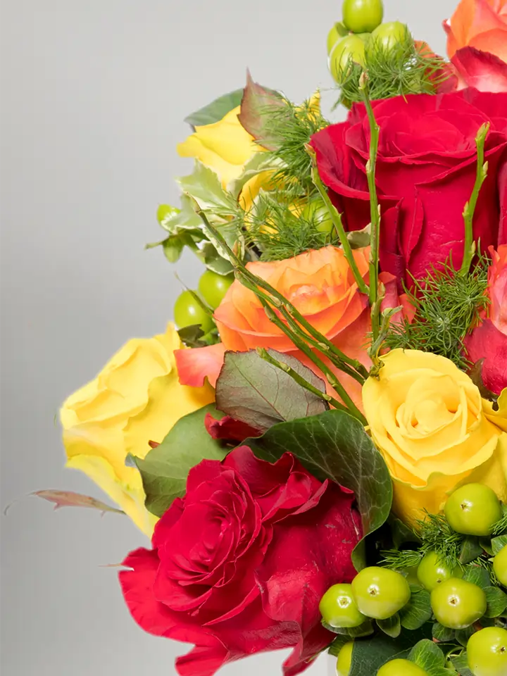 Bouquet di rose aranco rosse giallo e bacche verdi dettagli